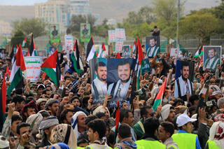 Houthis protest U.S. UK bombing holding pictures of leader Abdul Malik al-Houthi  